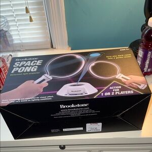 Brookstone Space Pong Light Projector Box in Black with Purple and Blue Accents